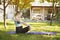 Pregnant woman in the garden practices yoga. Summer morning.