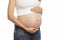 The pregnant woman gently touches her big belly. Waiting for a miracle. Close-up. Isolated over white background