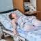 A pregnant woman gives birth in a hospital with a drip and a cardiotocograph machine