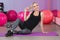 Pregnant woman in the gym sitting on the mat relaxing after training to keep fit yourself