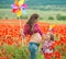 Pregnant woman and her daughter in poppy field