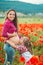 Pregnant woman and her daughter in poppy field