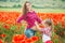 Pregnant woman and her daughter in poppy field