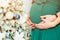 Pregnant woman and her handsome husband hugging the tummy, cropped image. Happy Christmas holiday