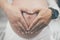 Pregnant woman and her husband hand splice hugging the tummy Heart shaped show love for the unborn baby in the belly relaxing at h