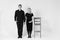 Pregnant woman and her husband holding hands in black clothes on a white background. Black and white picture. Family concept.