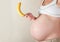 Pregnant woman holding a banana in a sexual way