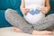 Pregnant woman holding blue socks