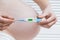 Pregnant woman holding electronic thermometer with normal temperature. Health during pregnancy