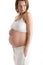 Pregnant woman holding exposed belly smiling