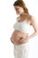 Pregnant woman holding exposed belly smiling