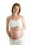 Pregnant woman holding exposed belly smiling