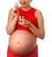 Pregnant woman holding glass of water and pills