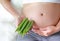 Pregnant woman holding green roselle at her belly. Dieting Concept. Healthy Lifestyle