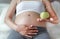 Pregnant woman holding guava at her belly. Dieting Concept. Healthy Lifestyle