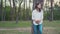 Pregnant woman holding her belly walking under summer tries