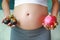 Pregnant woman holding mangosteens and dragon fruit at her belly. Dieting Concept. Healthy Lifestyle