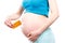 Pregnant woman holding medical pills or supplements, concept of vitamins in pregnancy