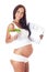 Pregnant woman holding scales and eating salad.