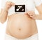 Pregnant woman holding ultrasound photo of embryo baby in belly