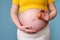 A pregnant woman holds a chicken egg in her hand