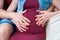 Pregnant woman holds hands on her belly, close-up. Concept of prenatal period, maternal health