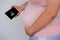 Pregnant woman holds mobile phone with ultrasound screen examination, small child rolls over in mother`s belly, concept pregnancy