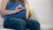 Pregnant woman with huge tummy hands peel off and eat banana fruit