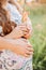 Pregnant woman hugging loving husband hands belly