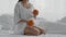 Pregnant woman juggling with oranges while sitting in bed at home