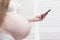 Pregnant woman in lingerie enjoys a smartphone. Call an ambulance. Prenatal contractions