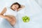 Pregnant Woman lying on the Bed with fresh Apples. Healthy Food