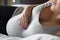 Pregnant woman lying on bed with her hand at belly