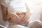 Pregnant woman lying in bed and touch her belly. Pregnancy heart shape at home, love sign