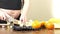 Pregnant woman makes a healthy smoothie in her kitchen, slices come bananas and oranges