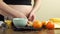 Pregnant woman makes a healthy snack in her kitchen, slices come bananas and oranges