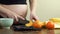 Pregnant woman makes a healthy snack in her kitchen, slices come bananas and oranges
