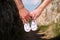 Pregnant woman and man holding baby shoes in hands. Future mom and dad, parents is holding little newborn baby shoes.