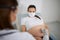 Pregnant woman in mask having ultrasound screening