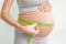 Pregnant woman measures her stomach. Pregnancy and weight gain. Pregnancy and sport. Big belly. Trimester