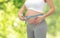 Pregnant woman measuring belly by tape measure