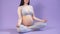 Pregnant woman mediating and keeping eyes closed while sitting in lotus position