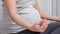 Pregnant woman meditates in lotus position at home