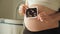 Pregnant woman middle body section holding the echography photograph of her baby in front of her belly.