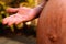 Pregnant woman with open palm hand beside her baby bump with stretch marks.