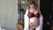 Pregnant woman with overweight in underwear and white cloak stroking belly.