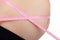 Pregnant woman with pink tape measure