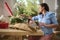 Pregnant woman preparing an arrangement of exotic flowers in wicker basket for special festive life event.