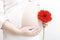 Pregnant woman with red flower