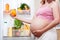 Pregnant woman and refrigerator with health food vegetables